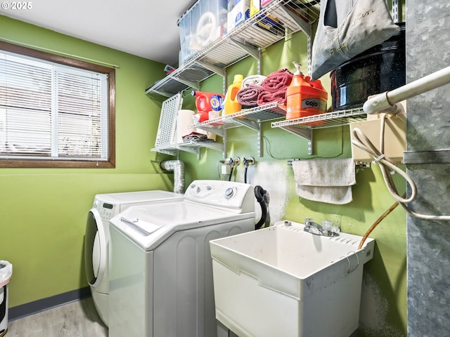 washroom featuring sink, washer and dryer, and light hardwood / wood-style floors