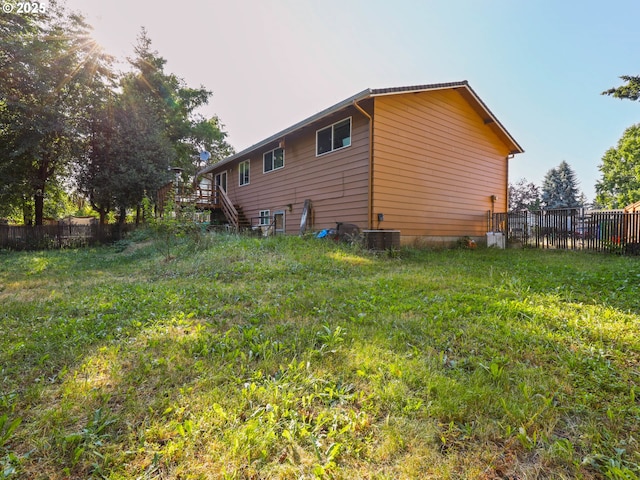 view of property exterior with a lawn and central AC