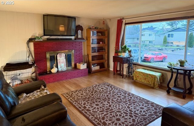 living room with hardwood / wood-style floors and a brick fireplace