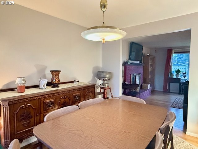 dining area with a fireplace and wood-type flooring