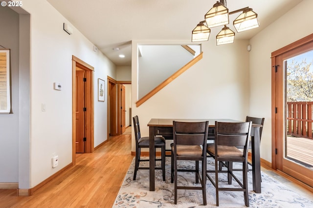 dining area with baseboards and light wood finished floors