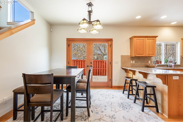 dining room with french doors, recessed lighting, a wealth of natural light, and light wood-style floors