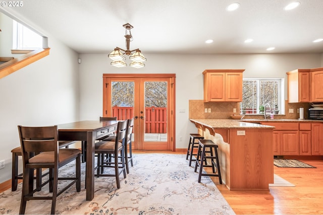 interior space featuring light wood finished floors, recessed lighting, baseboards, and french doors