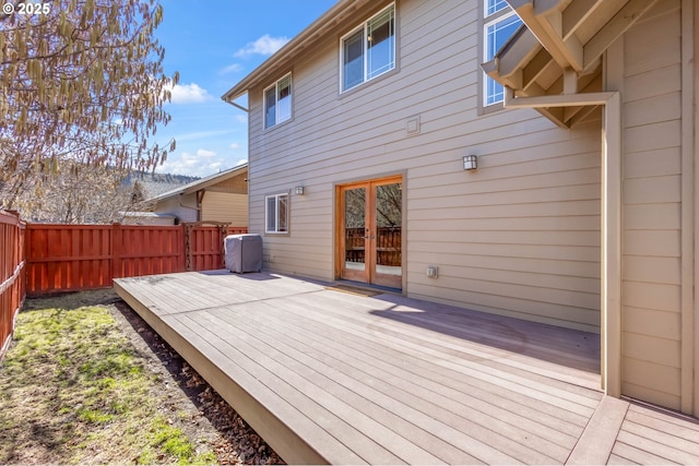 wooden terrace with a fenced backyard and french doors