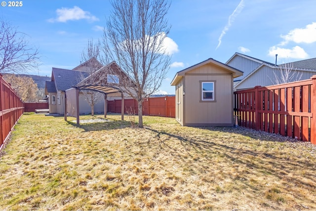 view of yard with a fenced backyard and an outbuilding