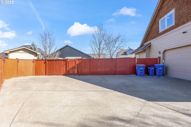 view of property exterior with a garage, a gate, and fence