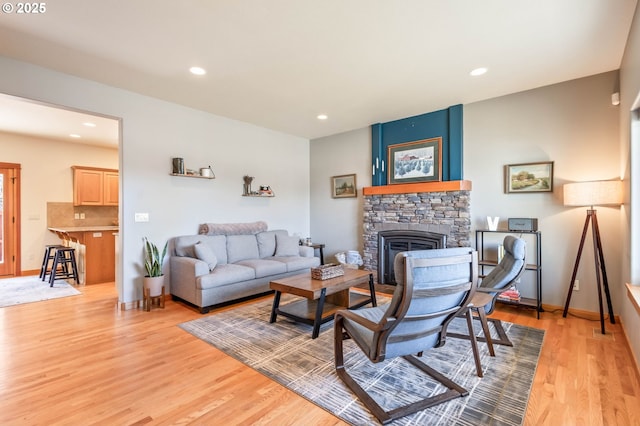 living room with baseboards, light wood finished floors, a fireplace, and recessed lighting