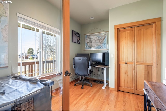 office space with french doors, baseboards, and light wood finished floors