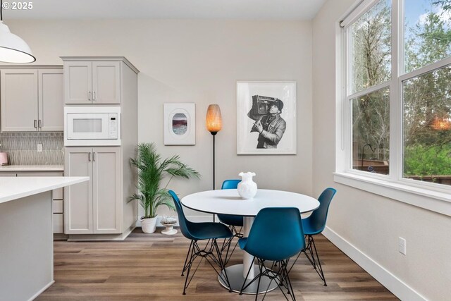 dining space featuring baseboards and wood finished floors