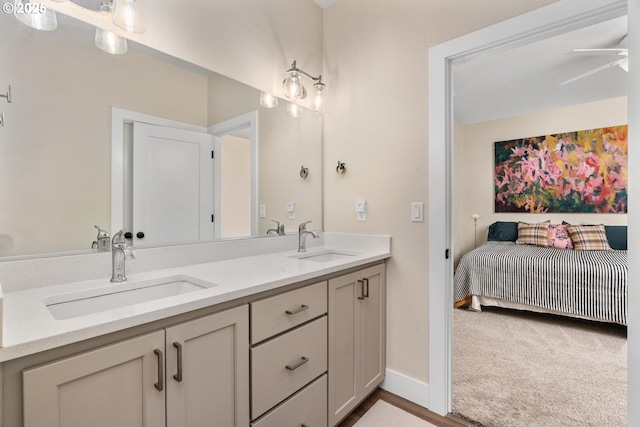 full bath featuring double vanity, a sink, ceiling fan, and ensuite bathroom