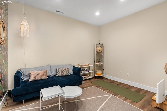 living area with recessed lighting, baseboards, visible vents, and wood finished floors