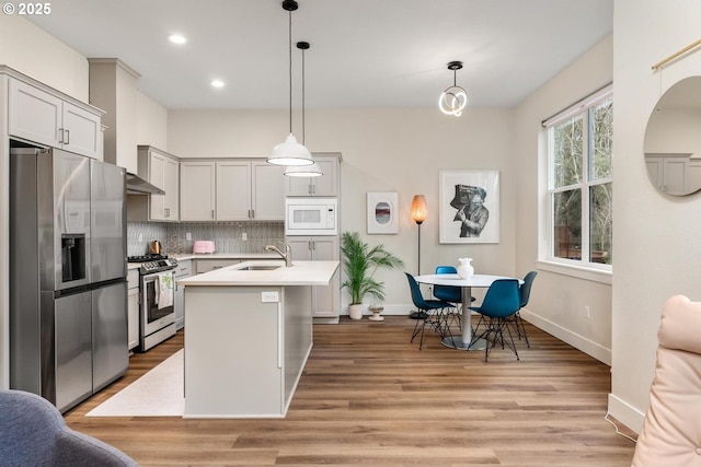 kitchen featuring decorative backsplash, recessed lighting, light countertops, a sink, and stainless steel appliances