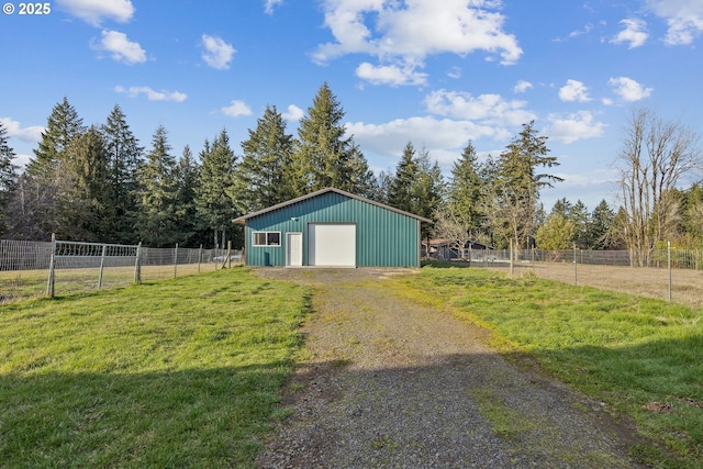 garage featuring a yard and a rural view