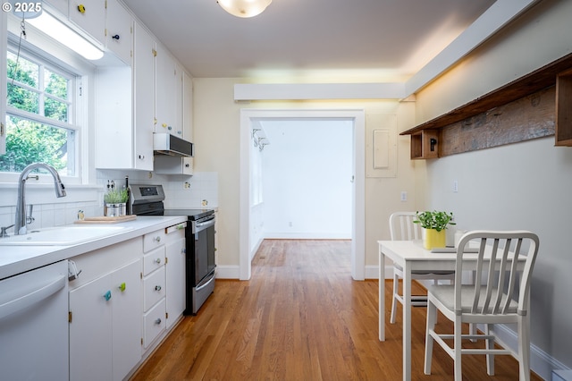 1856 SE Saint Andrews Dr, Portland, OR 97202 - kitchen with stainless steel range with electric stovetop, dishwasher, a sink, under cabinet range hood, and backsplash