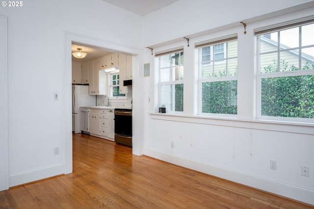 1856 SE Saint Andrews Dr, Portland, OR 97202 - kitchen featuring electric range, a sink, baseboards, light wood-style floors, and light countertops
