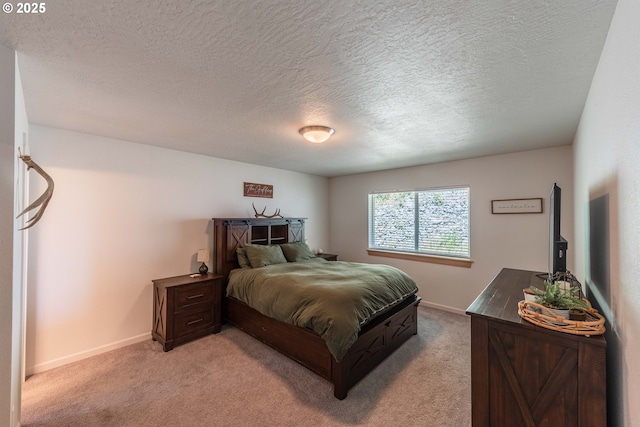 bedroom with light carpet, a textured ceiling, and baseboards