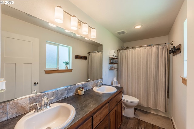 full bath featuring a sink, visible vents, toilet, and wood finished floors