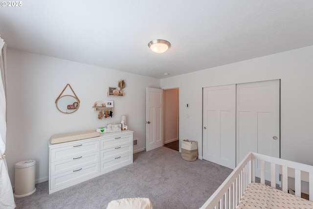 bedroom featuring a closet, baseboards, and light carpet
