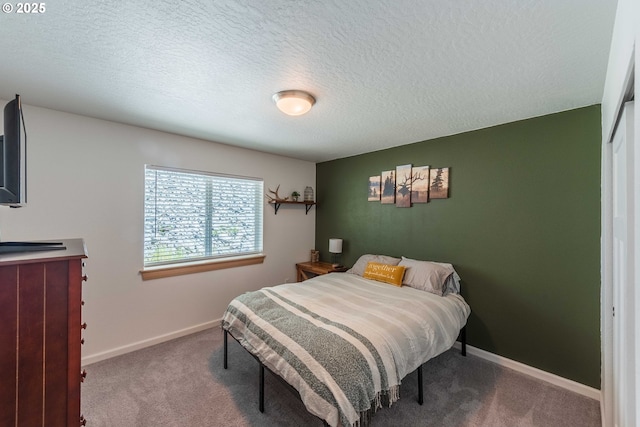 bedroom featuring baseboards, carpet, and a textured ceiling