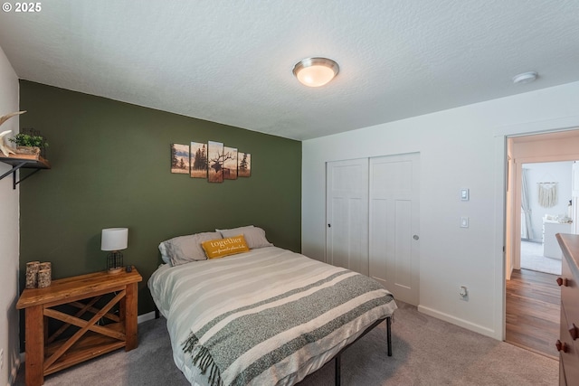 carpeted bedroom featuring a closet, baseboards, and a textured ceiling