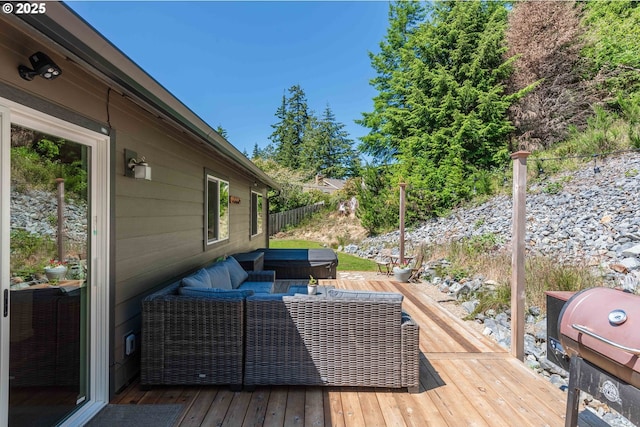 wooden terrace with a grill, fence, and an outdoor hangout area