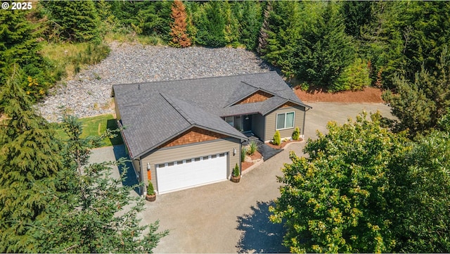 view of front of property featuring a garage, roof with shingles, and driveway