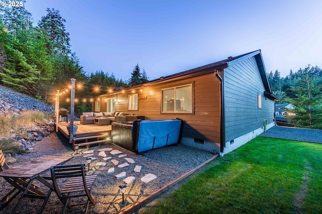 rear view of property with crawl space, an outdoor living space, a deck, and a lawn