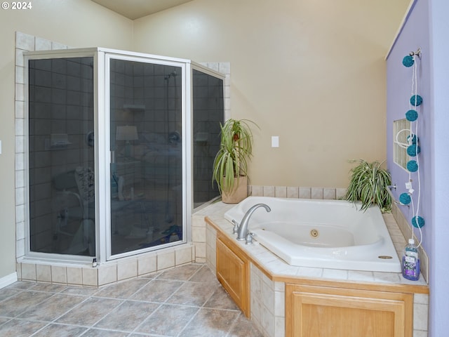 bathroom featuring a whirlpool tub, a stall shower, and tile patterned floors