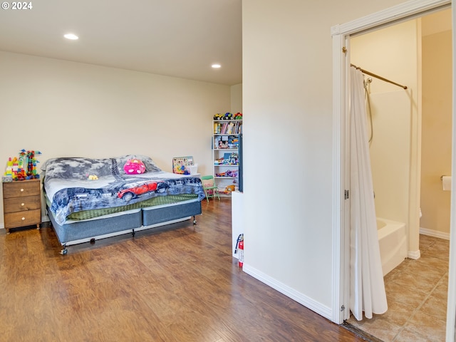 bedroom featuring baseboards, wood finished floors, and recessed lighting