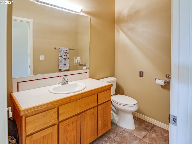 half bath featuring vanity, toilet, and tile patterned floors