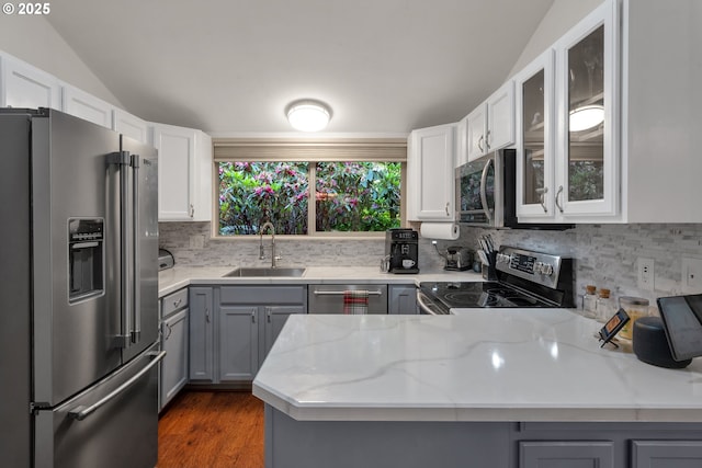 178 SW The Pines Dr, Depoe Bay, OR 97341 - kitchen featuring stainless steel appliances, a sink, a peninsula, gray cabinets, and vaulted ceiling
