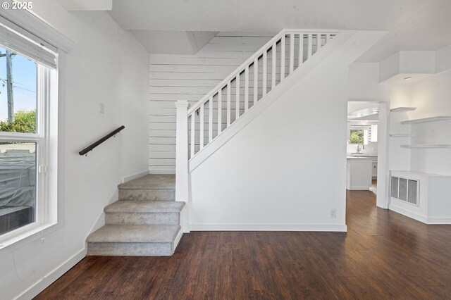 stairway with baseboards, wood finished floors, and visible vents