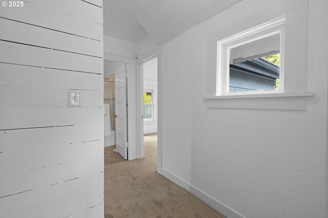hallway featuring baseboards and light colored carpet