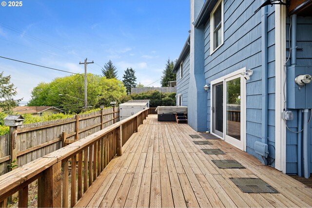 wooden deck with a hot tub and fence