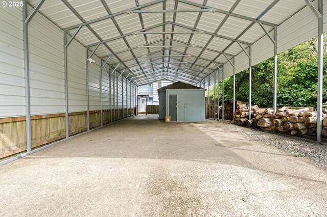 view of parking with a detached carport, a shed, and driveway