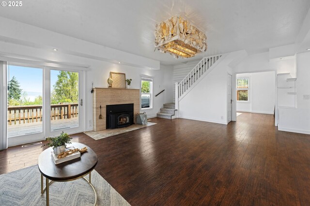 living area featuring stairway, baseboards, hardwood / wood-style flooring, and a wealth of natural light