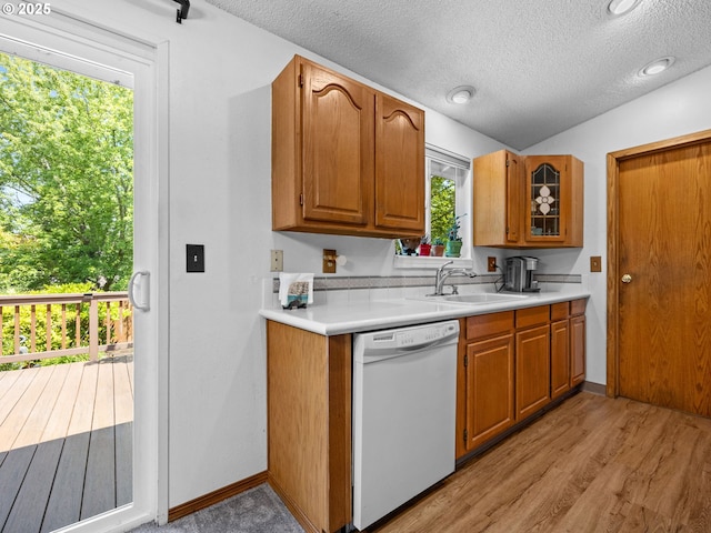 19085 SW Jaylee St, Beaverton, OR 97078 - kitchen with white dishwasher, light countertops, a textured ceiling, light wood-style floors, and brown cabinetry