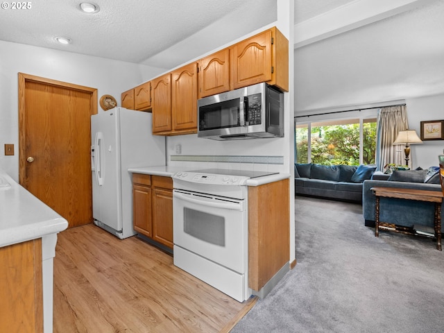 19085 SW Jaylee St, Beaverton, OR 97078 - kitchen with white appliances, light countertops, open floor plan, a textured ceiling, and light wood-style flooring