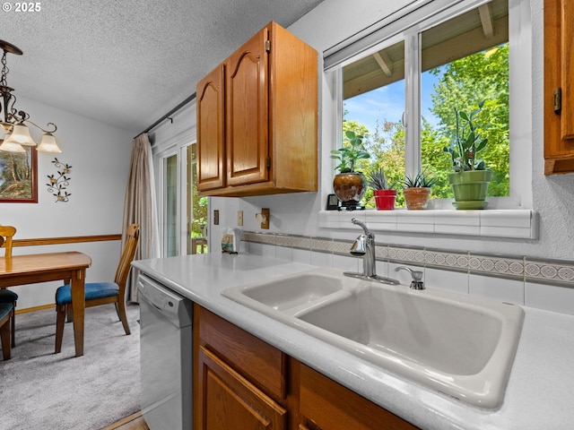 19085 SW Jaylee St, Beaverton, OR 97078 - kitchen featuring dishwasher, light countertops, a textured ceiling, light colored carpet, and brown cabinetry