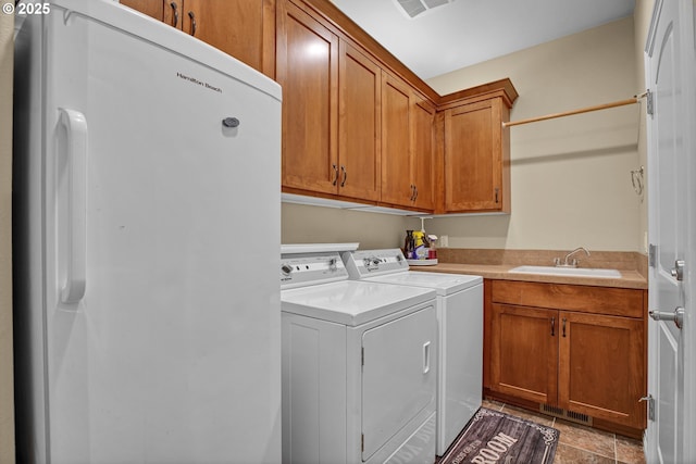 laundry room with a sink, separate washer and dryer, cabinet space, and visible vents