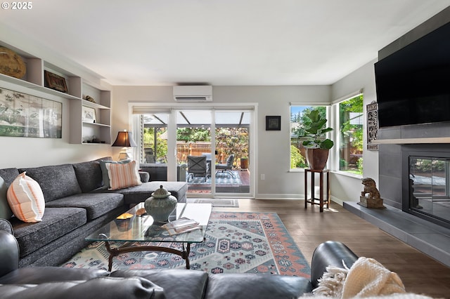 16760 SW Monaco Ln, Portland, OR 97224 - living area featuring a wall mounted air conditioner, a tiled fireplace, plenty of natural light, and wood finished floors