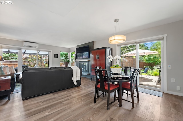 16760 SW Monaco Ln, Portland, OR 97224 - dining space featuring a wall mounted AC, light wood-style flooring, healthy amount of natural light, and a fireplace