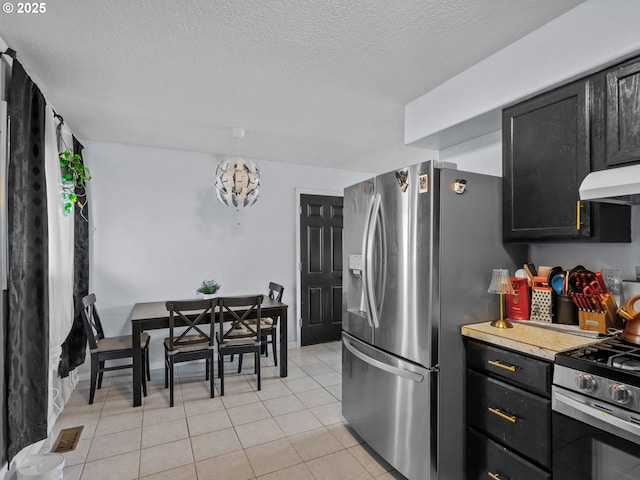 kitchen featuring an inviting chandelier, stainless steel appliances, a textured ceiling, and light tile patterned floors