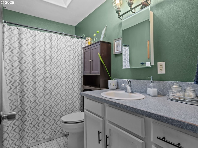 bathroom featuring tile patterned floors, vanity, toilet, and a skylight