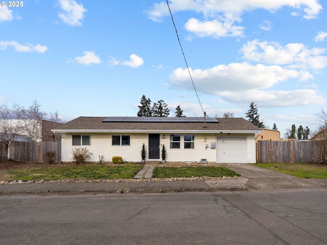 ranch-style house with a garage, a front lawn, and solar panels