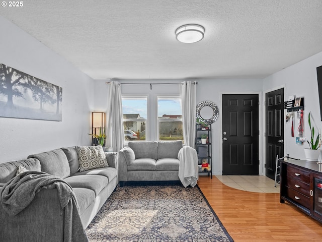 living room with a textured ceiling and light hardwood / wood-style flooring