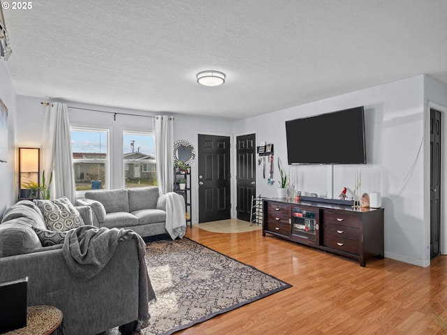 living room featuring light hardwood / wood-style flooring and a textured ceiling