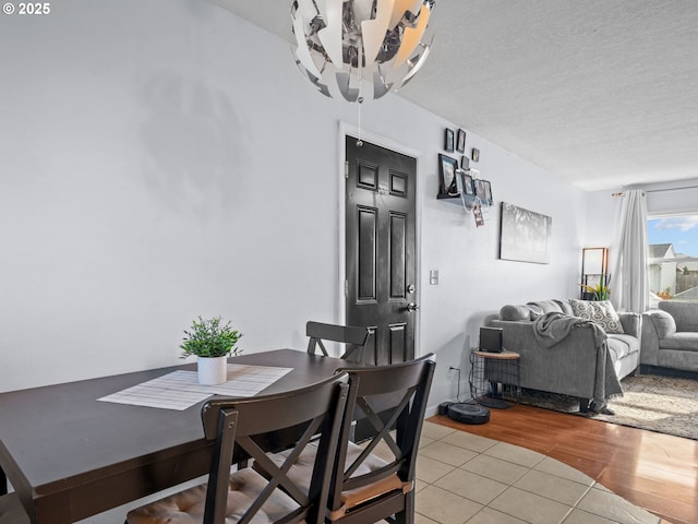 dining area with light tile patterned floors and a textured ceiling