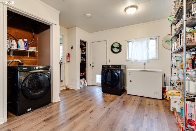 washroom with crown molding, laundry area, light wood-style flooring, and independent washer and dryer