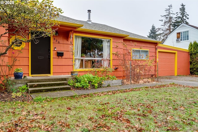 view of front of house featuring a garage, aphalt driveway, and a front yard